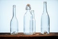 Four transparent glass bottles on a barn wood table in front of a white background Royalty Free Stock Photo