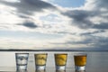 Four types of tequila shots lined up on seaside deck