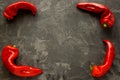 Four ugly paprikas lie at the corners of a black concrete background. Deformed red pepper on a dark background. Place for text Royalty Free Stock Photo
