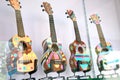 Four ukeleles on display behind a glass panel