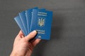 Four Ukrainian passports in mans hand on black background. Official document of Ukraine for trips abroad