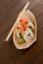 Four uramaki sushi served with chopsticks in wooden boat plate Royalty Free Stock Photo