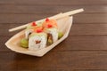 Four uramaki sushi served with chopsticks in wooden boat plate Royalty Free Stock Photo