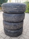 Four used car summer tires with wheels stacked Royalty Free Stock Photo