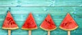 Four watermelon slice popsicles on panoramic blue wood background, fresh fruit concept Royalty Free Stock Photo