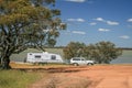 Four wheel drive vehicle and large caravan at roadside stop next to a lake in the outback of Australia