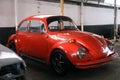 four-wheeled classic red Volkswagen beetle parked at the workshop in the afternoon Royalty Free Stock Photo