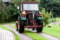 BIRMINGHAM, UK - March 2018 Four Wheeled Drive Mini Truck Hay Reaper in the Farm with Driver. Trees and Fruit Bearing