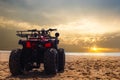 Four wheeler dirt bike on sand of sea beach during sunset Royalty Free Stock Photo