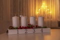 Four white advent candles on table with electic advent candlestick on background, the christmas period, adventsljusstake Royalty Free Stock Photo