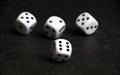 Four white and black dice on black table