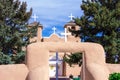 Four White crosses and an adobe church and wall
