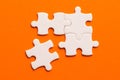 Four white details of puzzle on orange background Royalty Free Stock Photo