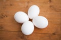 Four white eggs on the wooden background