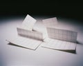 Four white paper sheets with a grid pattern are folded and arranged in a dynamic composition, creating abstract shapes and planes Royalty Free Stock Photo