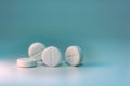 Several white pills on a blue-green background with turquoise Royalty Free Stock Photo