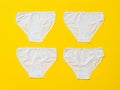 Four white women`s panties on a yellow background. Flat lay Royalty Free Stock Photo