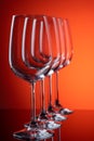 Four wine glasses in row perspective on red-orange background Royalty Free Stock Photo