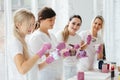 Four women mixing pants for creating abstract picture in white modern loft studio interior with big windows. Teamwork