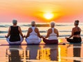 Four women practice yoga on the beach