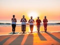 Five women practice yoga on the beach