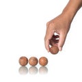 Four wood balls with human hand on white background.