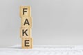 four wood cubes with the word FAKE on the background of white financial tatements, strong business concept Royalty Free Stock Photo