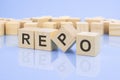 four wooden blocks with the letters Repo on the bright surface of a pale lilac background. the inscription on the cubes Royalty Free Stock Photo