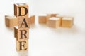 Four wooden cubes arranged in stack with text DARE meaning Define, Assess, Respond, Evaluate on them, space for text / image at