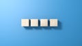 Four wooden cubes isolated on blue background.