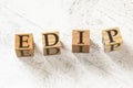 Four wooden cubes with letters EDIP meaning EXPLAIN DEMONSTRATE IMITATE PRACTICE on white working board. Royalty Free Stock Photo