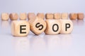 Four wooden cubes with the text 'ESOP' on a light gray background signify a financial concept related to