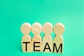 four wooden people with the inscription `team`. group work. teamwork. achievement of goals, corporate spirit. cohesion in the team