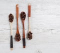 Four wooden spoons with roasted coffee beans creatively arranged
