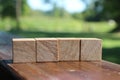 Four wooden toy cubes arranged on wooden table outside. Education concept Royalty Free Stock Photo