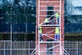 Four workers on the scaffolding clean the brick facade of the building