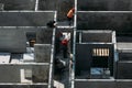 Four workers on the top floor of the building are installing concrete floors