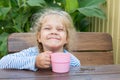 Four-year girl hamming sitting at a table with a glass of juice