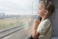 Four-year girl looks out the window of the train car