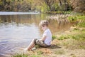 Boy sitting on shore of lake Royalty Free Stock Photo