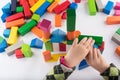 Four year old girl plays in the designer. Wooden toys, colorful children`s designer on white background, entertainment with a kid Royalty Free Stock Photo