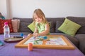 Little child playing parchis game at home in summer