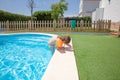 Child with armbands coming out of the pool by the curb