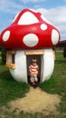 Four years old boy and toadstool house in a park Royalty Free Stock Photo