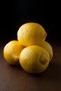 Four yellow fresh lemons on a wood table
