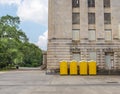 Four Yellow Portable Toilets Next to Building