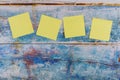 Yellow four sticker note in the blue old wooden background Royalty Free Stock Photo