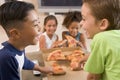 Four young children indoors eating pizza Royalty Free Stock Photo