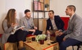 Four young entrepreneurs talking in a pleasant office spot while smiling