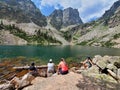 Four young hikers relax by Emerald Lake in Rocky Mountain Nat'l Park, Colorado.